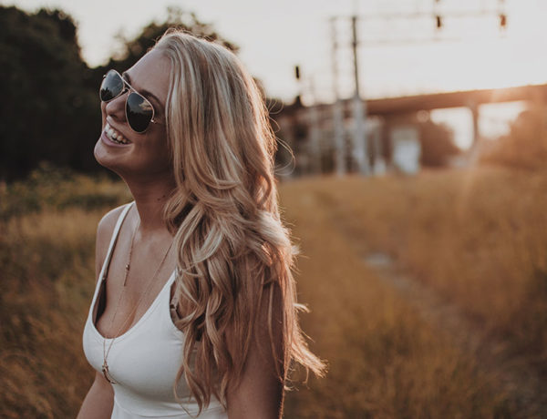 A tall woman dating, smiling in a field at twilight.