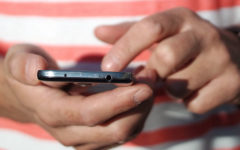 A close up on a guy’s fingers as he taps out a Tinder opening line on his phone.