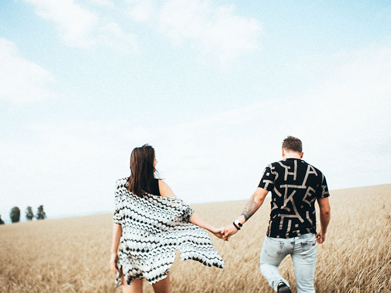 A couple walking in a field, holding hands. One of them has a fear of intimacy.