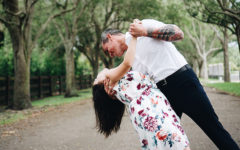 A couple in the senior dating scene, dancing in the park and laughing as the man dips the woman.