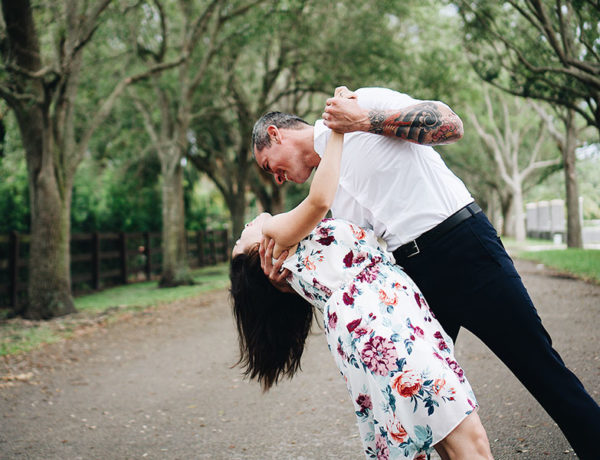 A couple in the senior dating scene, dancing in the park and laughing as the man dips the woman.