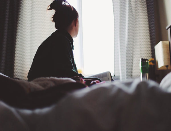 A woman looking out the window, thinking about her relationship and wondering why women pull away.