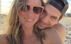 A girl who's dating a shy guy, smiling as her boyfriend grins next to her with his head on her shoulder.