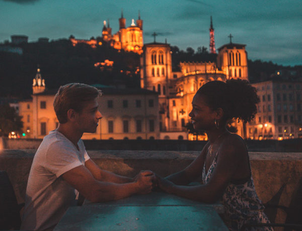 A woman using these personal questions to ask a guy, on a date with her boyfriend asking him questions as they hold hands.