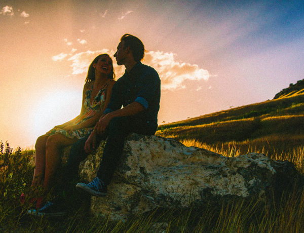 A couple who have consummate love, sitting next to each other at sunset.