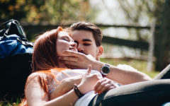 A girl wondering "Does he think about me" while sitting with him in the grass and flirting.