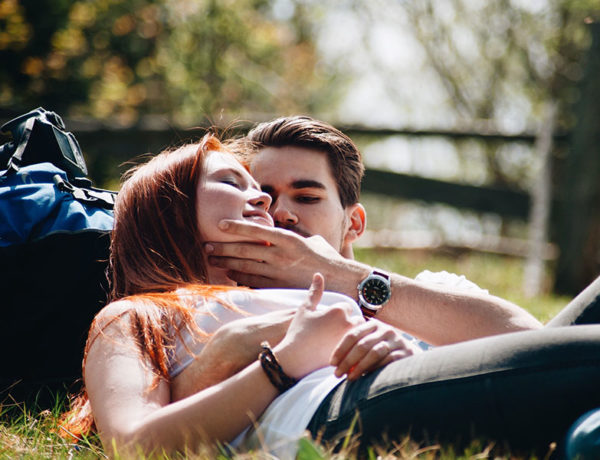 A girl wondering "Does he think about me" while sitting with him in the grass and flirting.