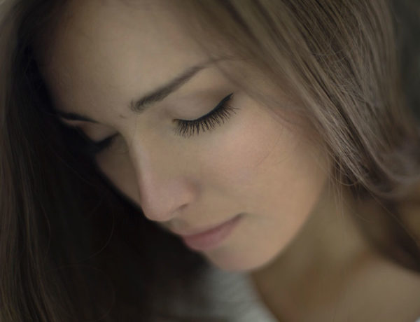 A woman who's feeling unwanted looking down and trying to reassess how she feelings.