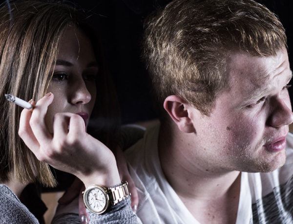 A woman smoking next to her date who thinks smoking is one of his main deal breakers.