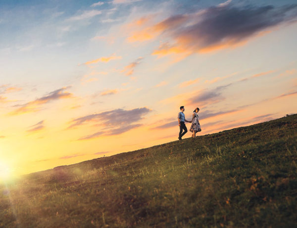 A couple who listened to this relationship advice climbing a mountain at sunset together.