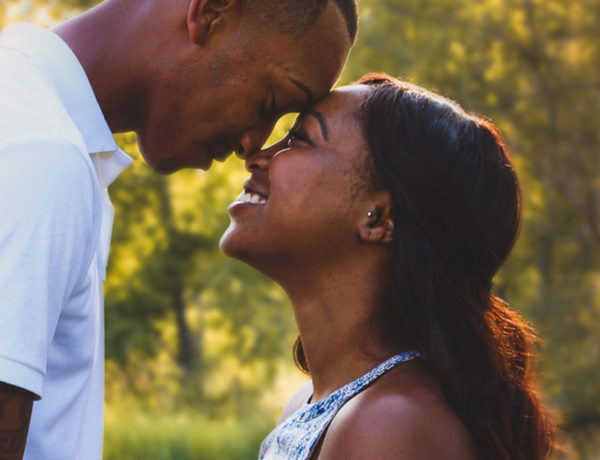 A couple laughing as they lean their foreheads together because they've found the one.