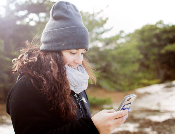 A girl texting on her phone with the guy she's dating and laughing.