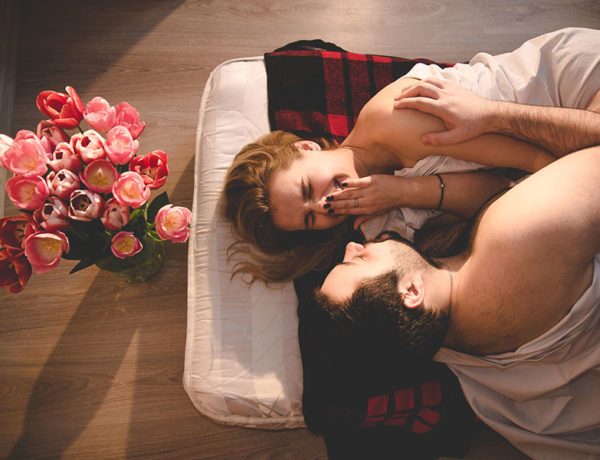 If you're wondering how to spice up your relationship, this couple laughing and flirting on a mattress on the floor surrounded by flowers may have an idea.