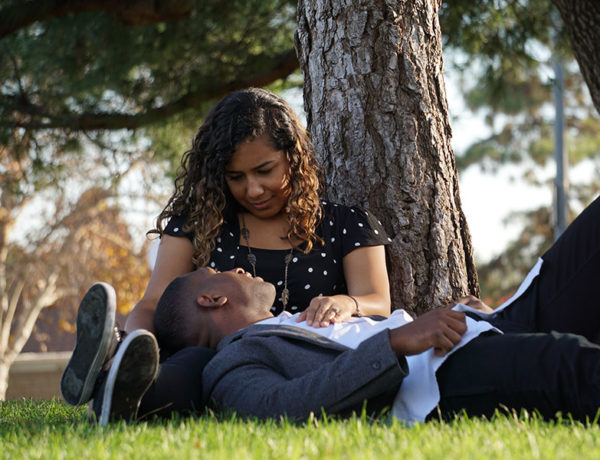 A couple who knows how to be good at communication in relationships, chatting outside in the grass.
