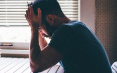 A guy who knows what it means to sabotage relationships, sitting in his kitchen with his head in his hands.