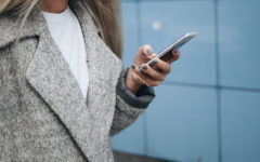 A woman wondering "Should I text him?" texting a guy she likes.