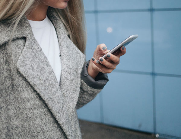 A woman wondering "Should I text him?" texting a guy she likes.