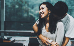 A couple who's showing signs of sexual tension, hugging and flirting at a party.