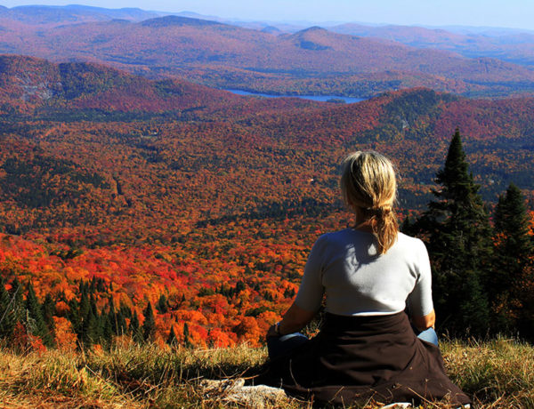 A woman after a breakup, sitting on a mountain meditating.