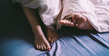A couple's feet sticking out of the sheets after they had first date sex.
