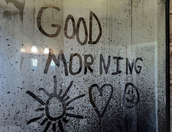 A message written on a rainy window that says good morning from a man who learned how to be romantic.