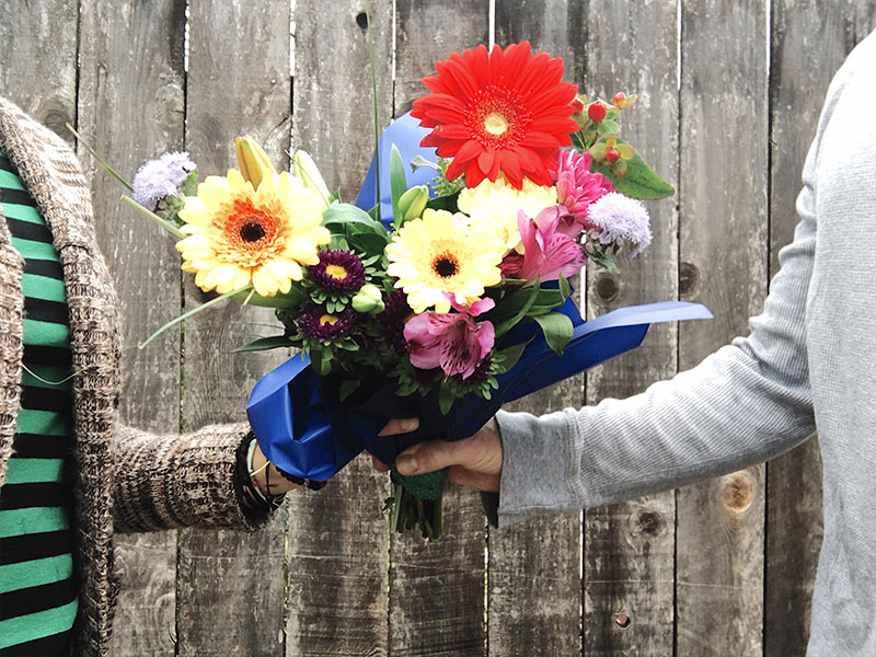 A man who found cute ways to ask a girl out, handing a girl flowers before seeing if she'll go on a date with him.