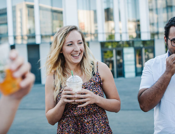 A women who is learning how to stop thinking about someone, out with her friends drinking coffee and laughing.