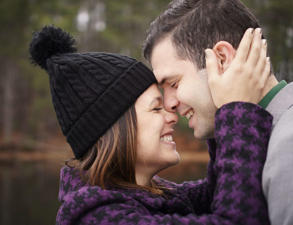 A woman who knows what it's like being single at 40, laughing and she leans against her boyfriend before they kiss.