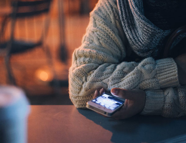 A girl at a bar double texting a guy.