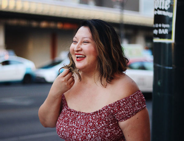 A woman laughing and smiling as she gets over a heartbreak.