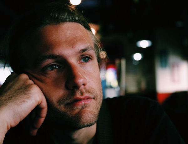 A man going through a divorce, at the bar sipping a drink and thinking.