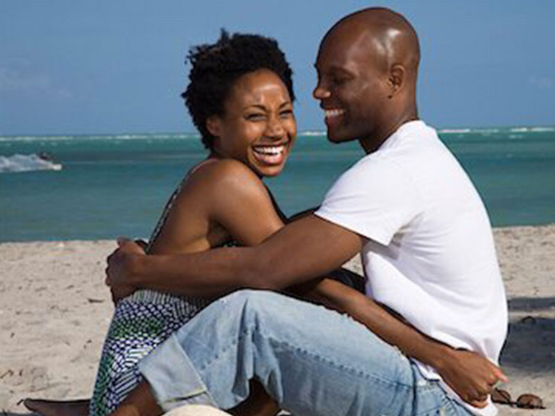 A couple over 40 dating, hugging and laughing together on the beach.