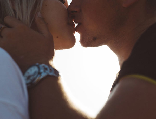 A man who wants to know how to prove you love someone, kissing his girlfriend at twilight.