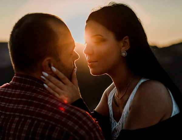 A couple who's showing signs of love, looking into each other's eyes intensely before kissing.