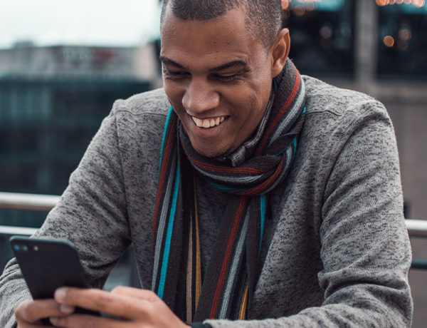 A guy receiving one of these cute texts for him and laughing and smiling at his phone.