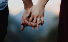 An engaged couple holding hands, ready to get pressure from their family.