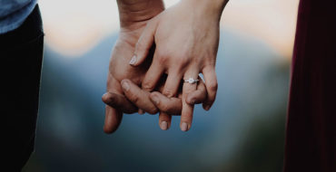 An engaged couple holding hands, ready to get pressure from their family.