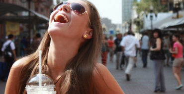 A girl laughing really hard after a guy asked her one of these flirty questions to ask a girl.