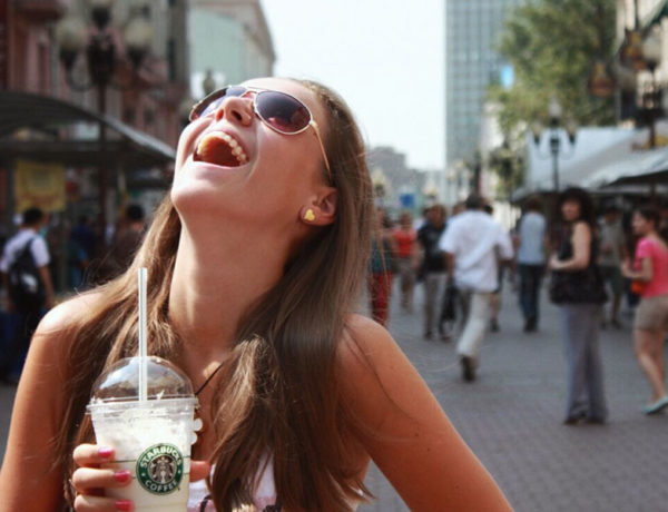 A girl laughing really hard after a guy asked her one of these flirty questions to ask a girl.