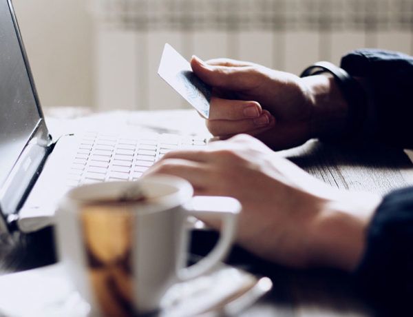A person talking to an online dating scammer about to share their credit card information while sitting at their computer.