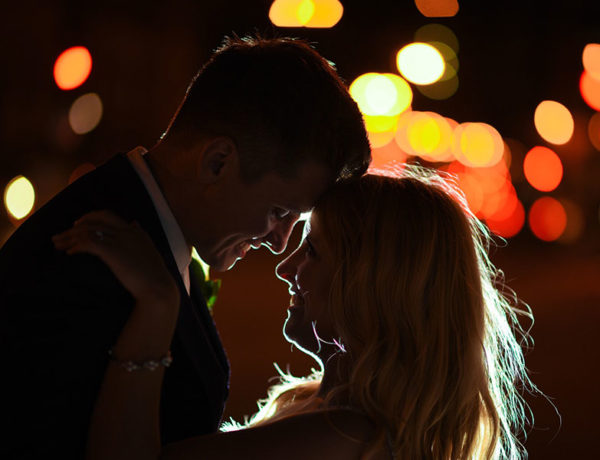 A woman who believes in love at first sight, looking into her boyfriends eyes before they kiss outside at night.