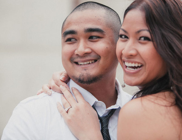 A woman who practices positive self talk, smiling with her fiance as they hug outside.