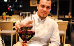 A guy on a first date cheersing his date across the table.