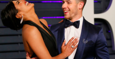Nick Jonas and Priyanka Chopra, one example of an older woman dating younger men, laughing and hugging at a red carpet event.