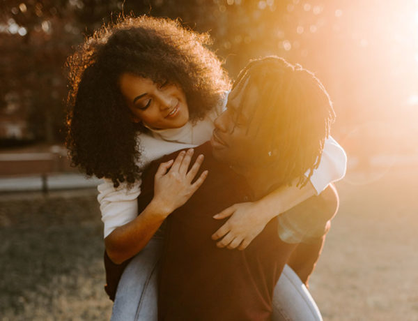 A man who thought he wasn't a natural flirt, smiling at a girl on his shoulders who's smiling back at him.