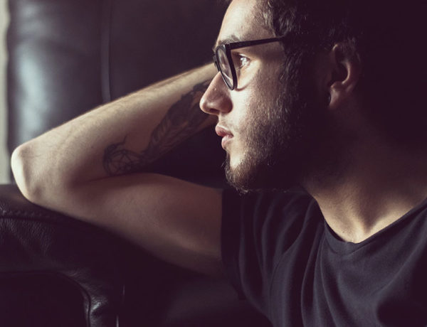 A man suffering from unrequited love looking out the window and thinks.