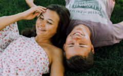 A guy who used one of these creative first date tips, laughing in the grass with his date.
