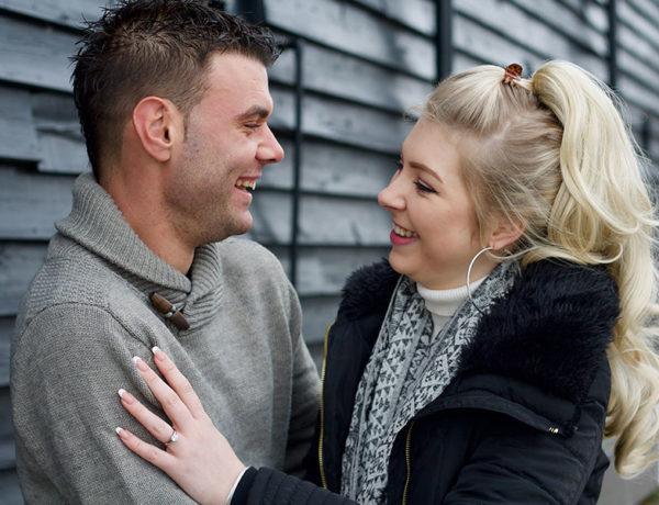 A girl who learned how to tell if a guy is using you, looking at her boyfriend as they hug and wondering how he feels.