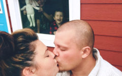 A woman who's a single parent and dating, kissing her date while her kids are inside pushing their faces against the window and making funny faces.