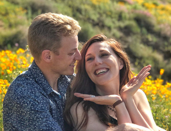 A woman who's potentially coming on too strong smiling up at her boyfriend in a field.